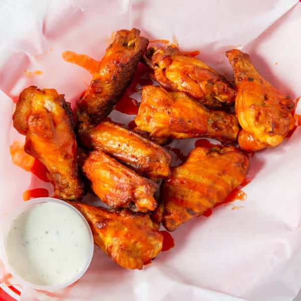 Rock Creek Pizza's buffalo wings, saucy and golden brown, with a side of ranch dressing.
