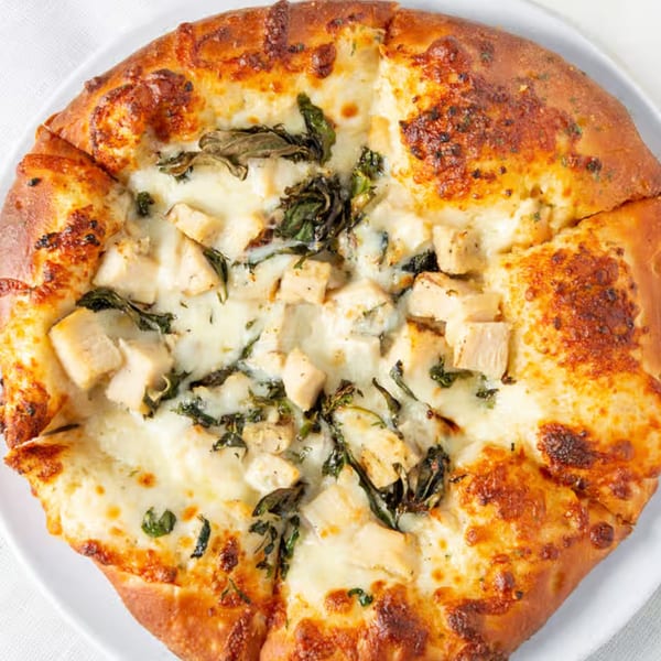 Rock Creek Pizza's chicken and spinach pizza, topped with melted mozzarella cheese and golden crust.