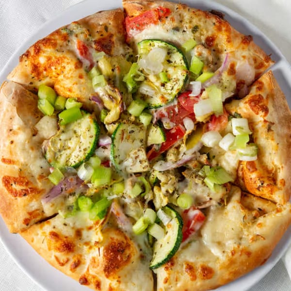 Rock Creek Pizza's veggie pizza with zucchini, tomatoes, red onion, and green onions.