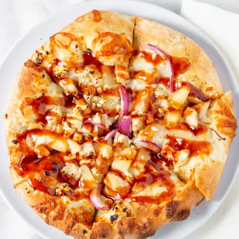 Rock Creek Pizza's BBQ chicken pizza, topped with chicken, red onion, pineapple, and BBQ sauce.